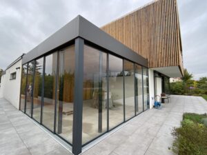 Zasklená pergola s moderním posuvným zasklením u rodinného domu