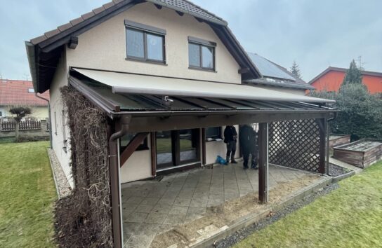 Rekonstrukce střechy pergoly: výměna polykarbonátu za čiré bezpečnostní sklo Connex v hnědých profilech RAL 8017.